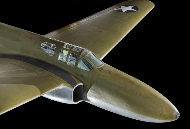 View of the cockpit of a green painted plane. 