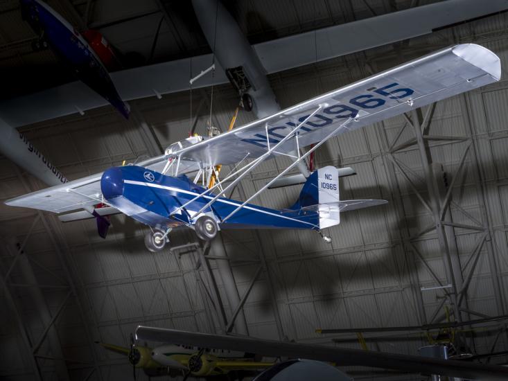 Blue and silver bi-plane hanging in the museum. 