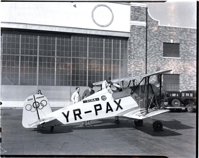 Profile of the Jungmeister with Olympic rings on the tail. Black and white photo. 