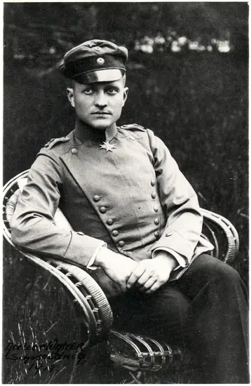 A middle aged white man in German military uniform, sits angled to the side, staring at the camera. 