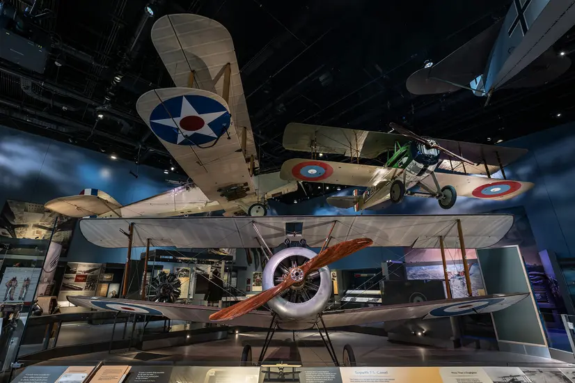 World War I era biplanes overlap each other in the viewers siteline in this photograph taken inside the gallery, giving the effect of a dogfight or planes taking off for their missions. 