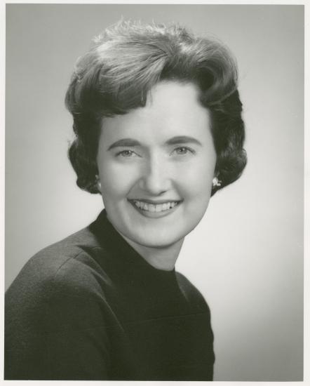 Black and white portrait of a woman smiling.