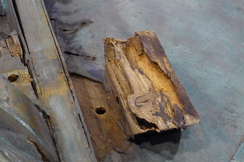 Examples of softwood deterioration on the interior of a World War II era aircraft. The wood is missing multiple layers in different spots.