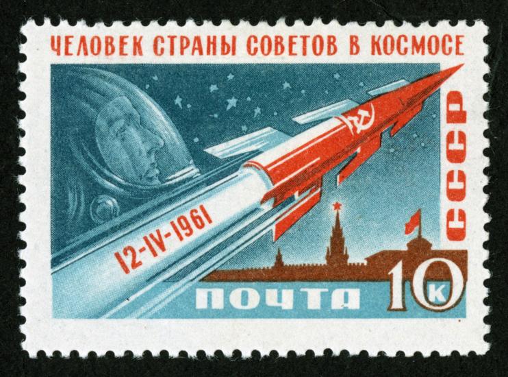 Russian ten-kopek stamp commemorating the first human spaceflight accomplished by Yuri Gagarin. The stamp features a depiction of a red rocket soaring above a Kremlin building, with a depiction of Gagarin in the sky.