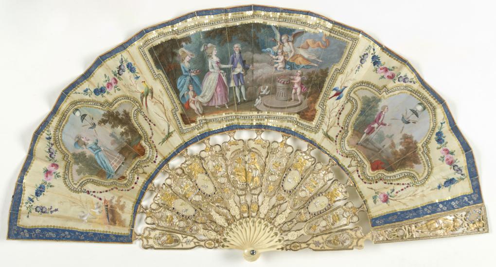 Ornate, ivory decorative fan with depictions of people watching air balloon launches.