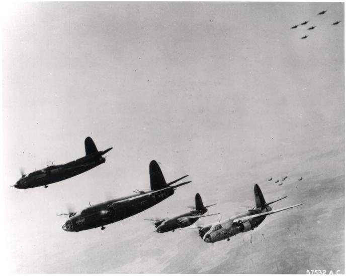 A group of four bomber aircraft fly in the sky during a mission during World War II.