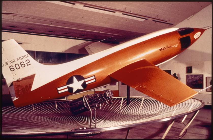 Side view of orange and white military monoplane. Registration number "6062" painted on the fin in black paint.