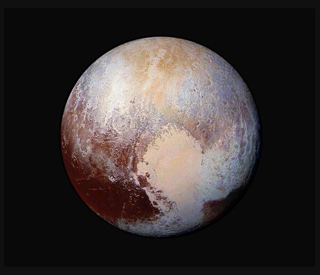 Disk view of Pluto with false colors to emphasise the different topographies of the planet. A heart shape is visible on the lower right quadrant. 