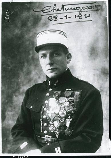 Portrait of Charles Nungesser, a French World War I pilot, as he sits wearing his military uniform with military decorations on his right chest.