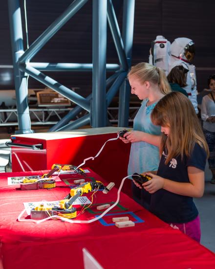 Two museum visitors participate in a robot activity as part of an astronaut game at the Museum's Steven F. Udvar-Hazy Center.