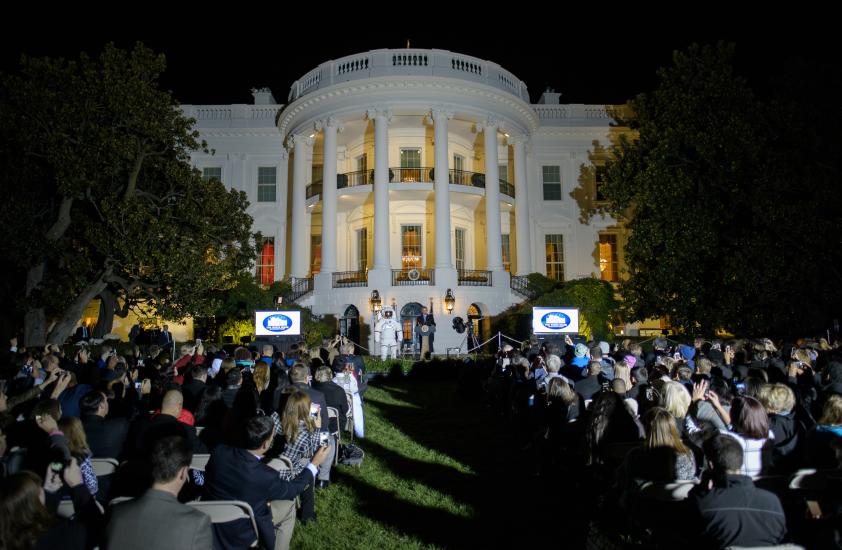 View of the White House exterior during an astronomy event held there. President Obama is speaking to a group of people.