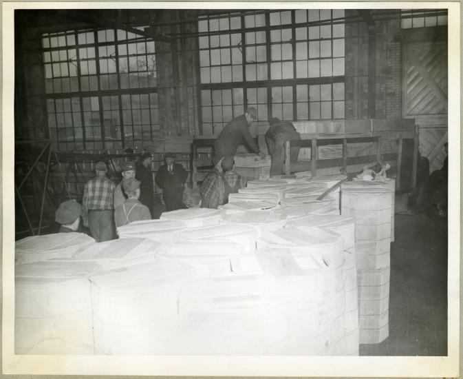 A group of men employed with the Northwestern Aeronautical Corporation unload cases of turkeys prior to a holiday giveaway to employees.