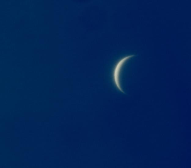 Daytime view of Venus, which is seen as a crescent shape.