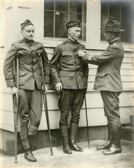 A male second lieutenant receives a service medal. The lieutenant is injured and using a cane.