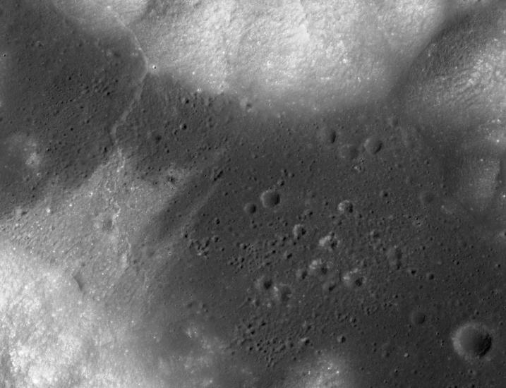 Satellite view of a region of the Moon that is mostly flat but features some small craters.