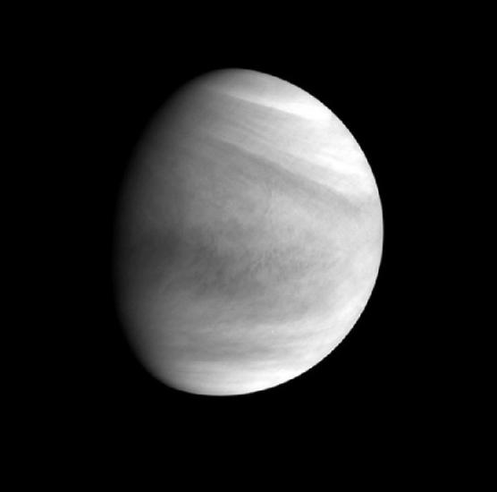 Partial disk view of Venus, with the sun reflecting on part of the planet. The reflection gives it a gibbous appearance.