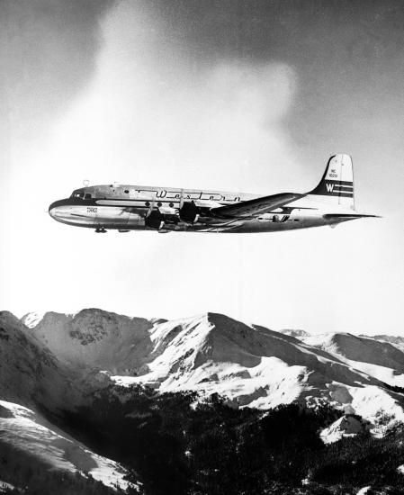 Side view of commercial aircraft in flight. Aircraft features Western Airlines livery.