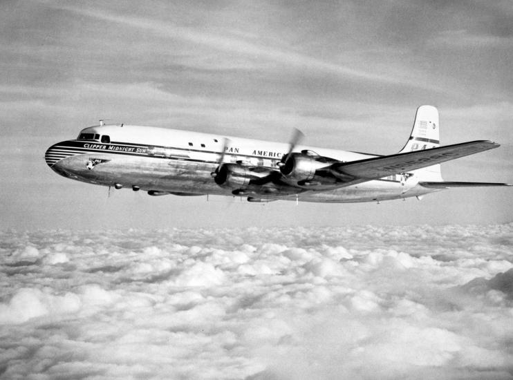 Side view of commercial aircraft in flight. Aircraft features four engines and Pan American Airways livery.