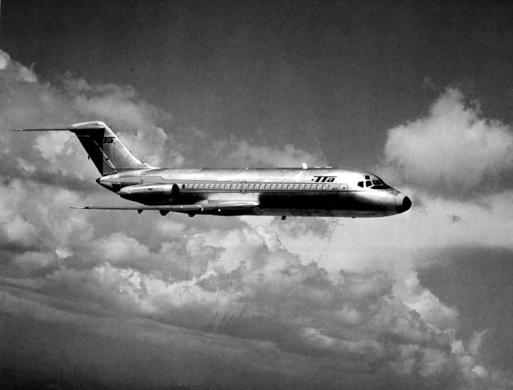 Side view of commercial jet aircraft in flight. The jet features Trans-Texas Airlines livery and has two engines placed near the rear of the fuselage.