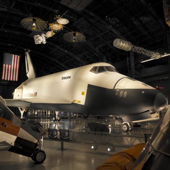 Side view of white and black space shuttle on display at the museum.