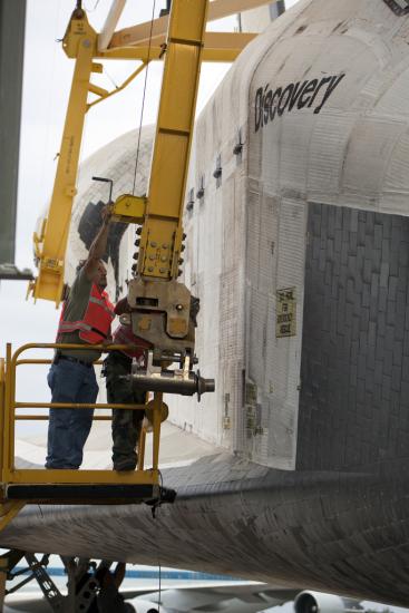 A lifting sling is placed on the Space Shuttle Discovery prior to the mate-demate device lifting the spacecraft onto a shuttle carrier aircraft.