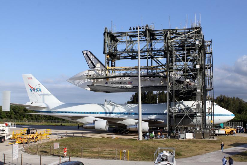 The Space Shuttle Discovery is lifted and ready to be placed on top of an aircraft designed to carry space shuttles.