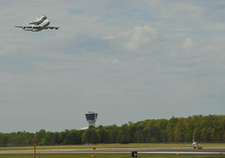 The Space Shuttle Discovery, attached to an aircraft modified for transporting shuttles, flies above Washington-Dulles airport prior to landing.