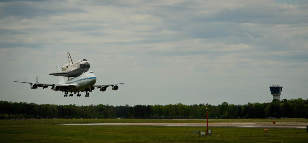 Space Shuttle Discovery, attached to an aircraft modified for shuttle transport, lands at Washington Dulles International Airport.