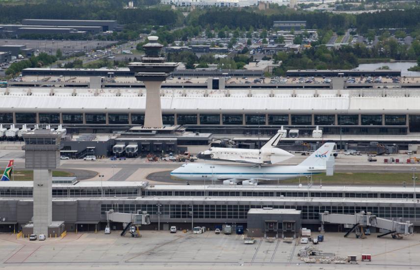 Space Shuttle Discovery, attached to an aircraft modified for shuttle transport, taxis on the runway at Washington Dulles International Airport.