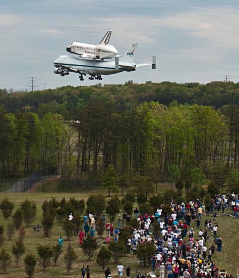 Space Shuttle Discovery flies low over crowd