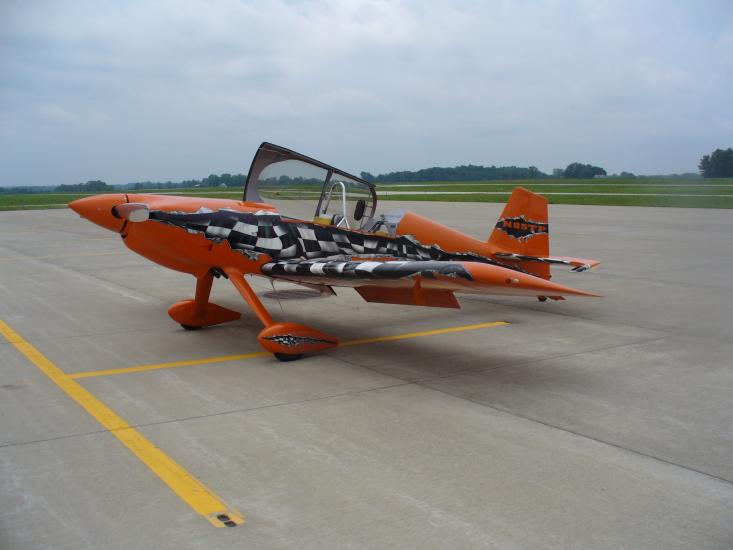 An orange aircraft with black and white painted accents and fixed landing gear.