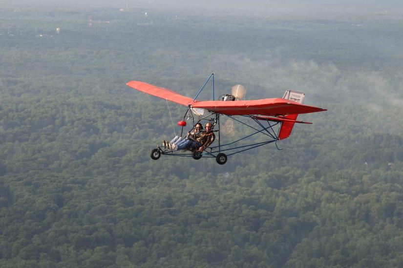 Red-winged ultralight aircraft with seating for two people.