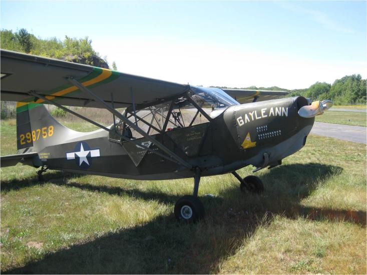 Side view of gray-colored monoplane with name "Gayle Ann" written on the side of the nose. A star is painted behind the cockpit and registration number 298758 is painted in yellow on the vertical stabilizer.