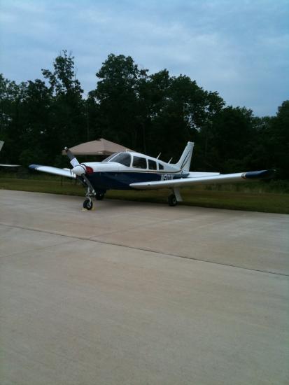 Frontal side view of a white and blue airplane with one propellor attached to the nose.