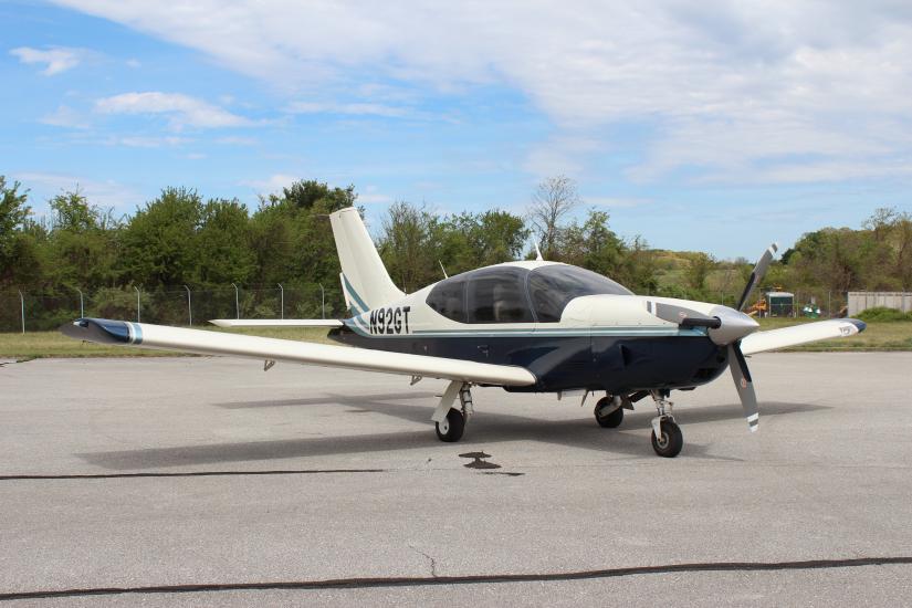 Frontal side view of white and black airplane with single engine. Registration number "N92GT" is painted near the rear of the fuselage.