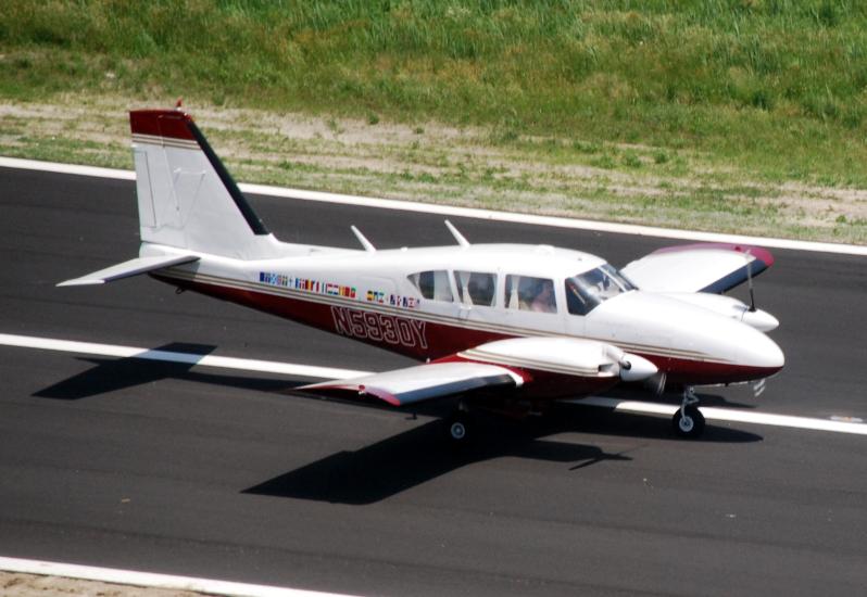 Side view of white and red monoplane with twin engines.