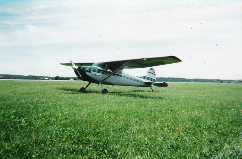 Side view of white monoplane with single engine.