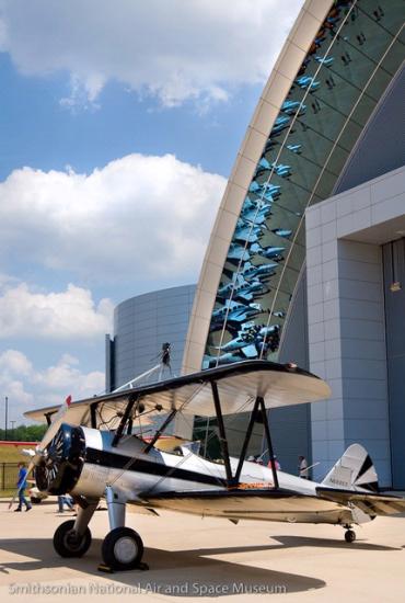 Side view of white and black biplane with single engine.