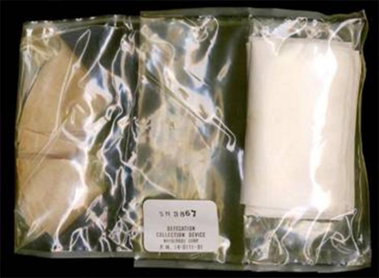 A clear package featuring a fecal collection device and wipes. The outer package is marked for its purpose.