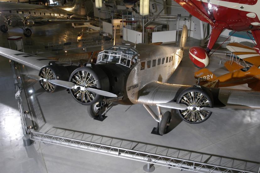 Silver-colored and black monoplane with three engines displayed in the museum.