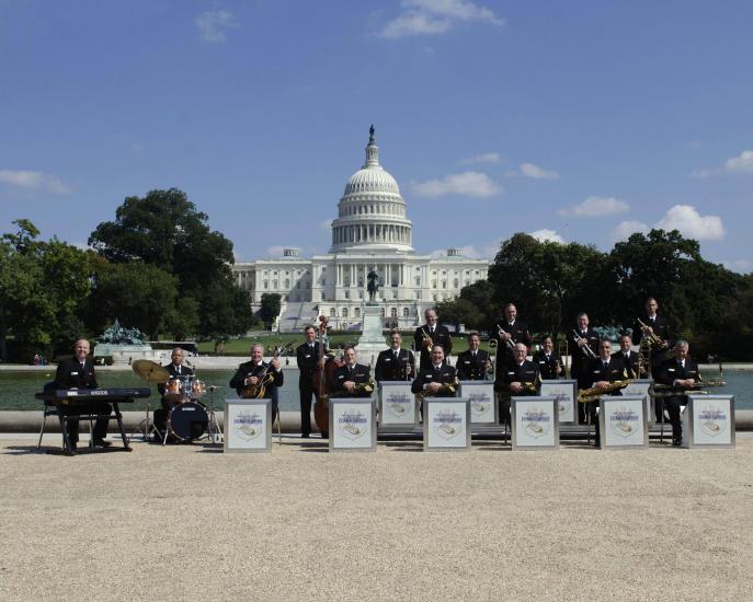 A group of jazz musicians in an ensemble stand outside the U.S. Capitol building.