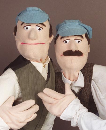 Two puppets dressed as the Wright brothers pose for a portrait.