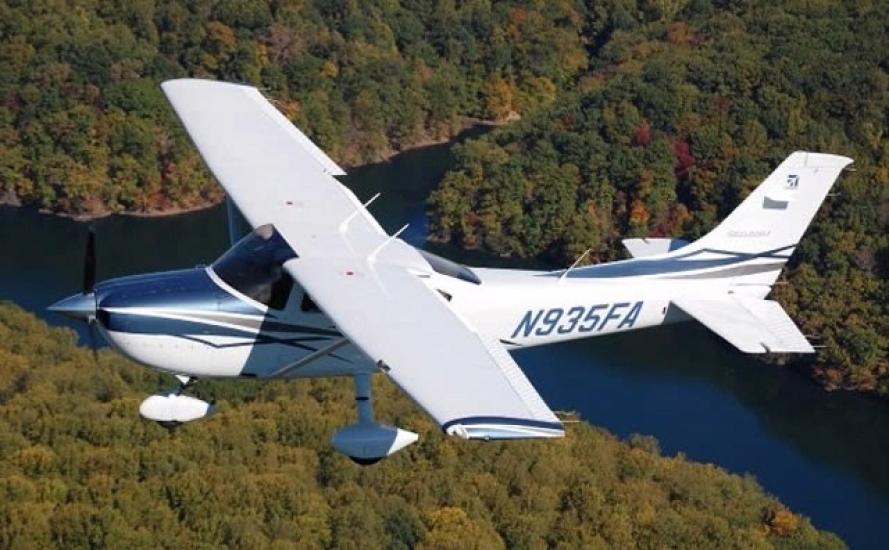 Top and side view of white monoplane with single engine and fixed landing gear. Registration number "N935FA" is painted in a dark blue color near the rear of the fuselage.