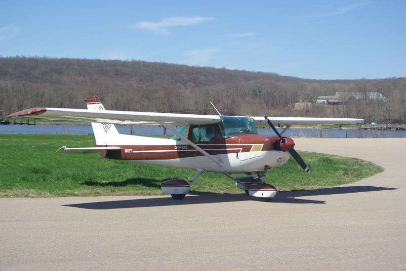 Side view of white and brown monoplane with single engine and fixed landing gear.