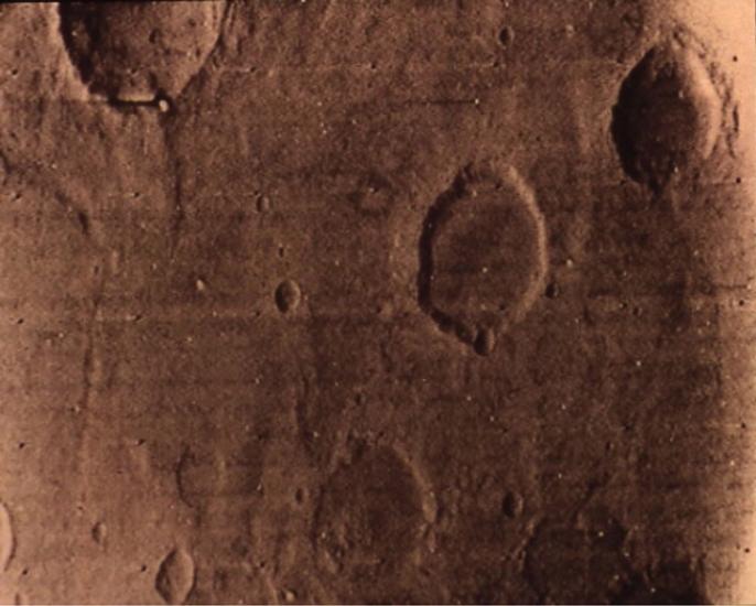 A partial view of Mars from orbit, showing off craters on the surface.