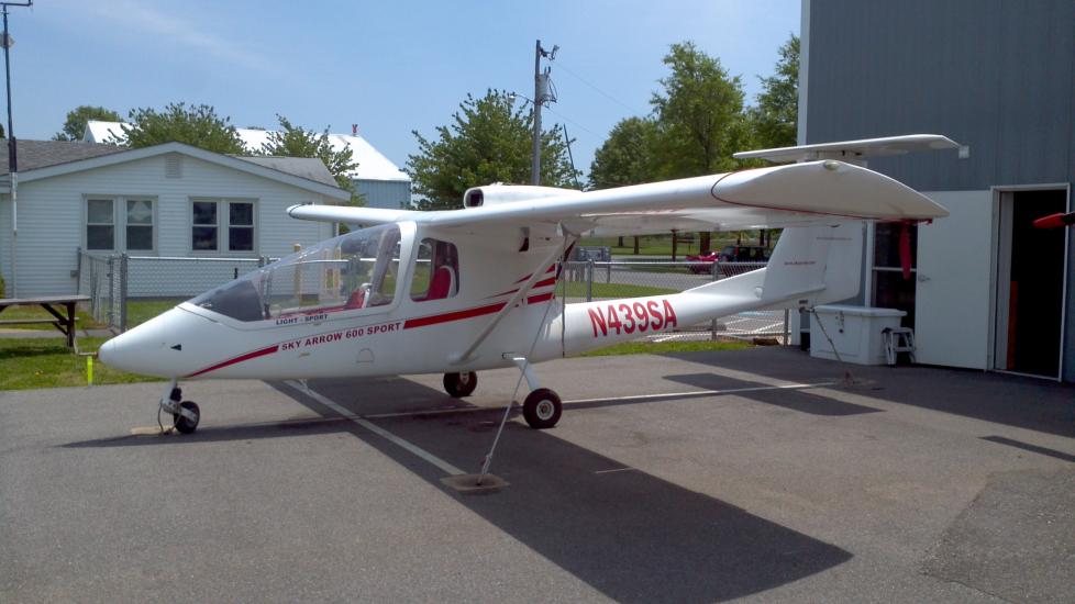 Side view of white monoplane with red accents and a single engine. The registration number N439S4 is painted in red between the fuselage and the vertical stabilizer.