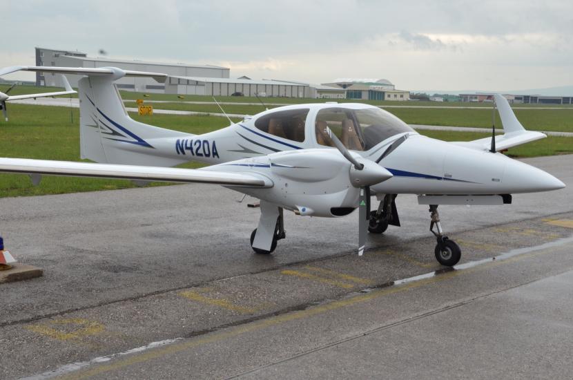 Side view of white and blue monoplane with twin engines. Registration number "N420A" is painted in blue near the rear of the fuselage.