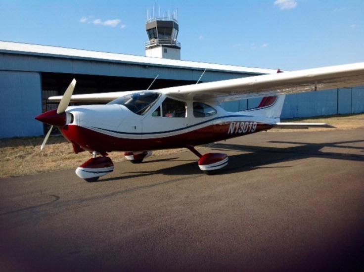 Side view of white and red monoplane with single engine and fixed landing gear. Registration number "N13019" is painted in red between the fuselage and vertical stabilizer.