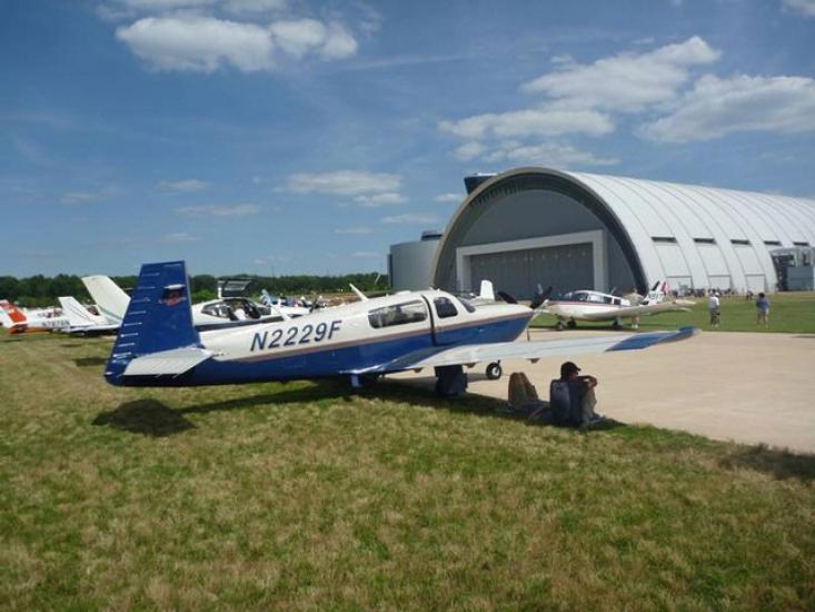 Side view of white and blue monoplane with a single engine. Registration number "N2229F" is painted in blue near the rear of the fuselage.