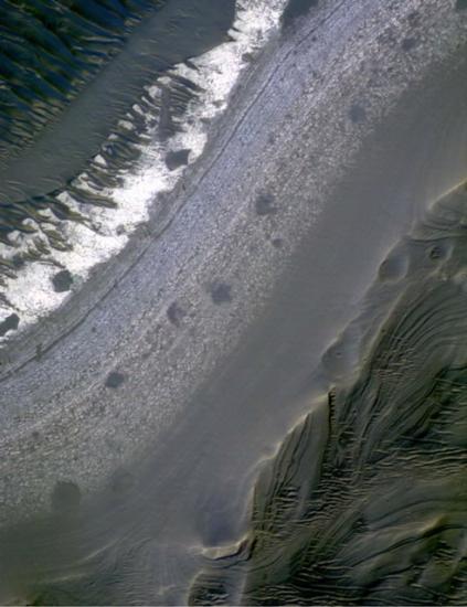 Satellite image of a crater on Mars featuring beds of fine scales, which look like thinly drawn lines.